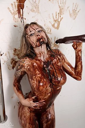 Naked gadget Lily Xo is covering her horny body with the chocolate streams