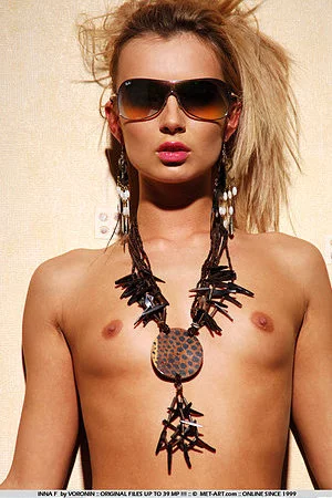 The blonde babe Inna F poses in hat, in sexy stockings and in sun glasses