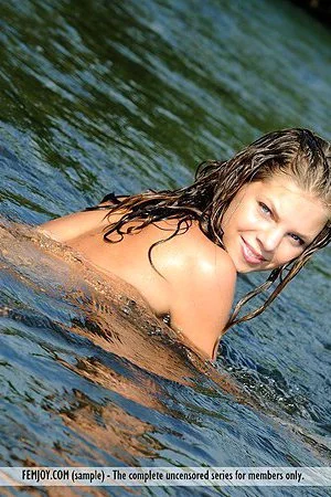 Passionate poses are taken by the beautiful Olivia E that is playing around in the river