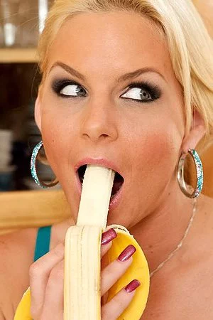 The lusty blonde Phoenix Marie shows big tits downblouse and erotically eats banana