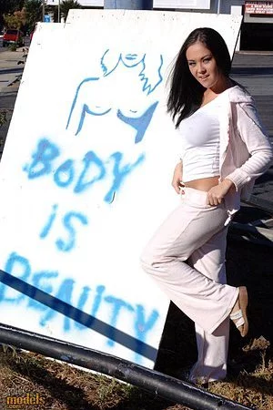 Exotic asian chick Dee Lily dressed in white flashes her perfect round tits