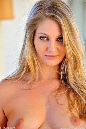 Lovely blonde babe Veronica Weston flashes her tits and pantyless pussy then strips her dress