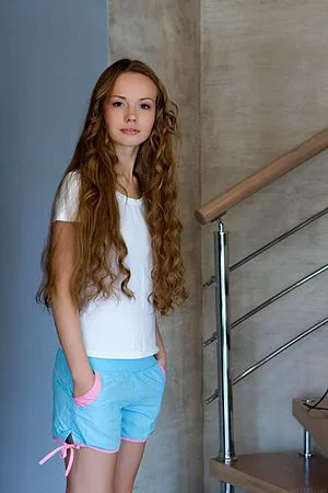 Lusty teen doll with curly hair Virginia Sun bares her corset and panties then sexily poses