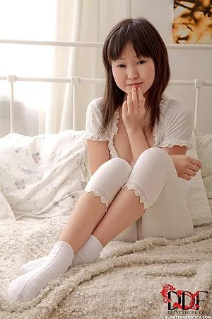 Sexy Asian teen Aliona L plays in the bed stripping her white pajamas and socks