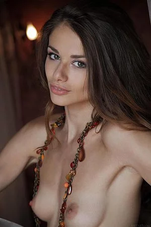 Curly haired brunette Loretta A poses showing her naked pussy with puffy labia