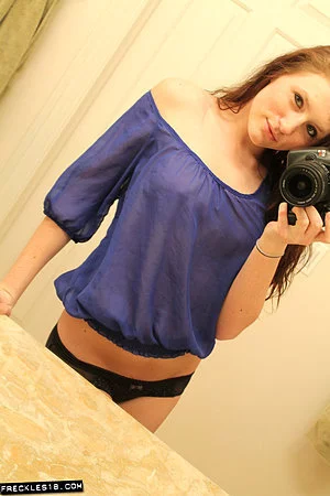 Freckles takes photos of herself in the mirror and we see her boobs through her shirt