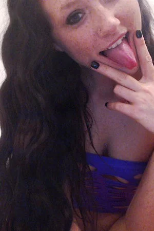 Brunette Freckles puts on a slutty, purple outfit and teases in a softcore gallery.