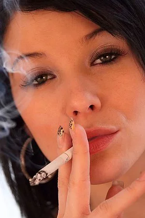 Raven haired Adrianne Black in fur coat flashes her boobs as she smokes a cigarette