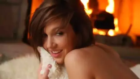 The half naked babe Lacey Lynn is ling at the fireplace and showing nude charms